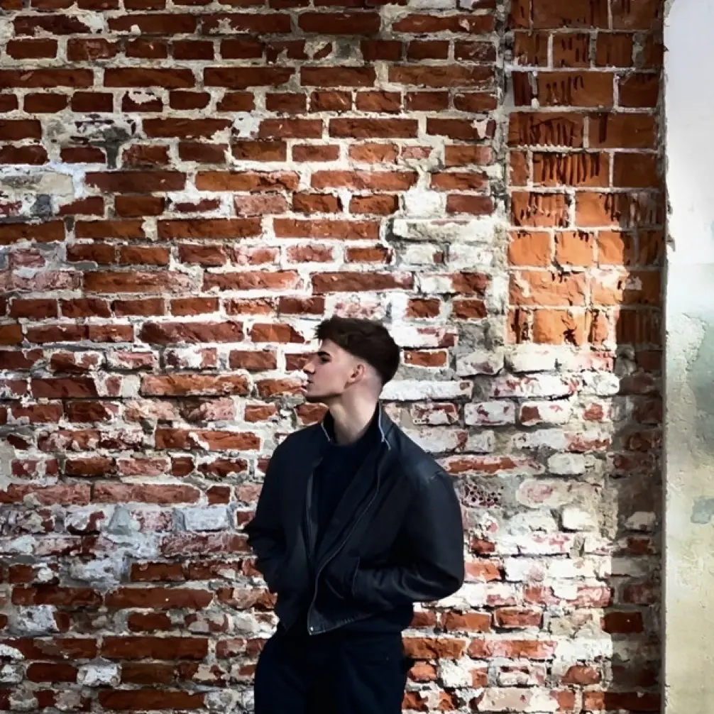 Author standing in front of a brick wall